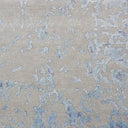 Close-up of textured fabric with abstract blue pattern on neutral base.
