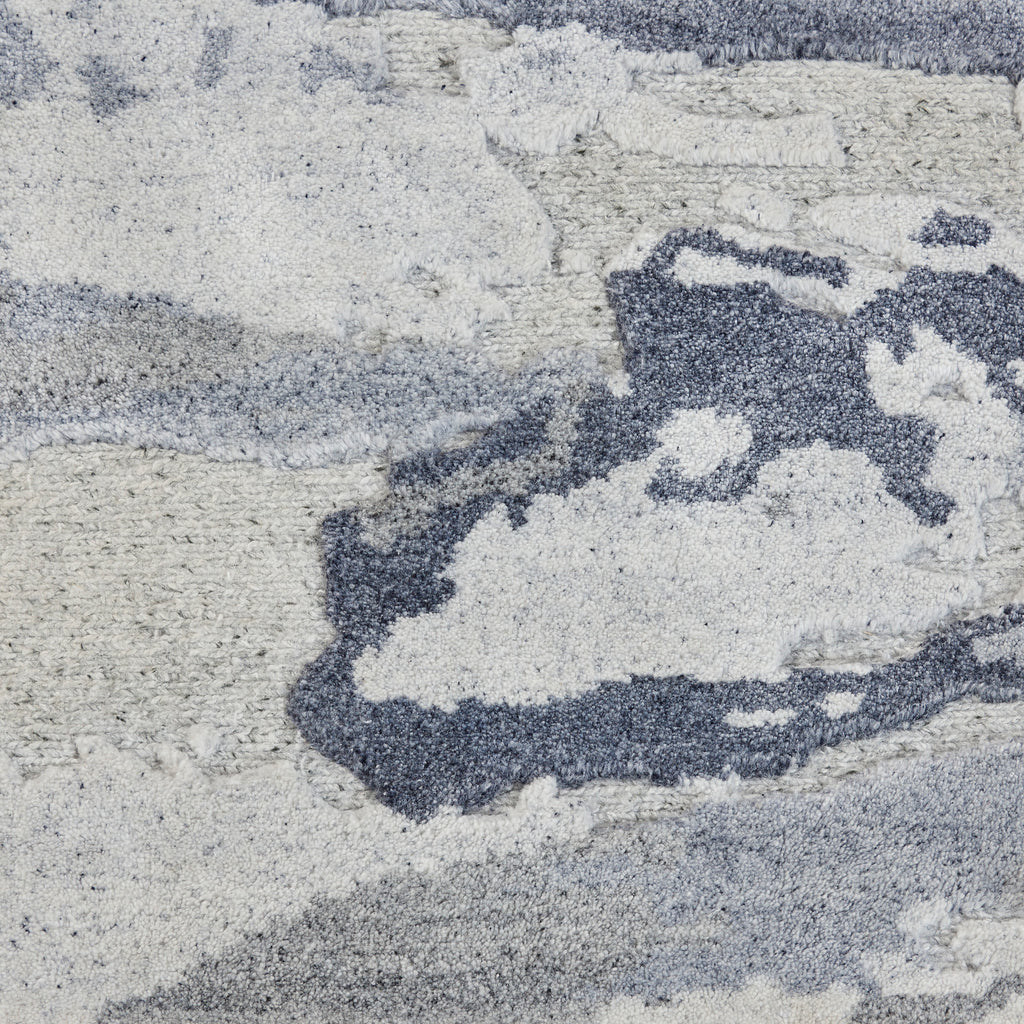 Close-up of a plush, abstract blue and grey carpet design.
