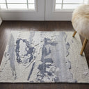 Abstract patterned rug adds modern flair to sunlit hardwood floor.