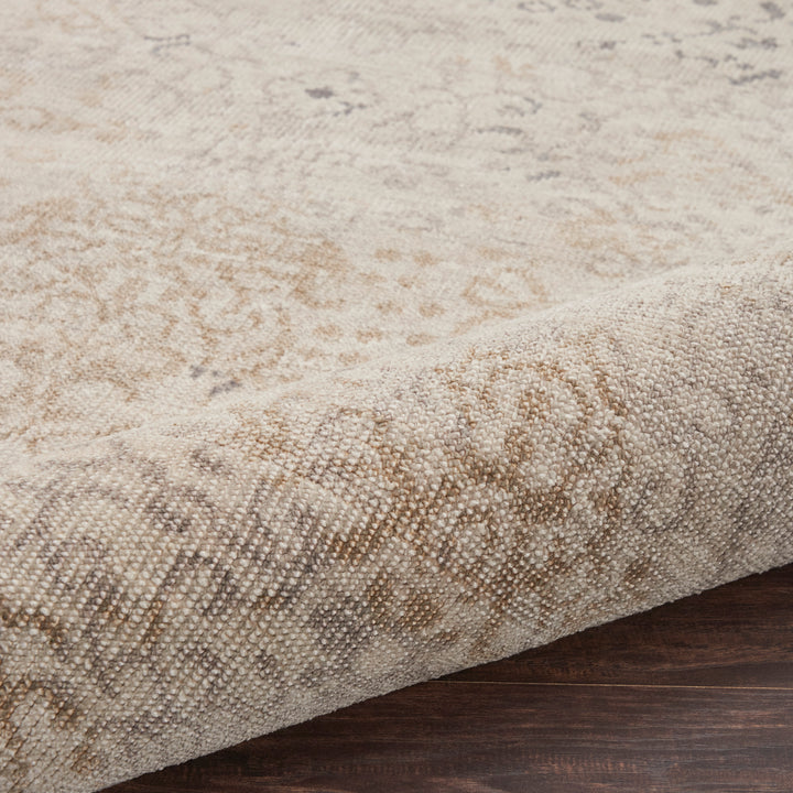 Close-up of a plush, beige rug with blue decorative elements.