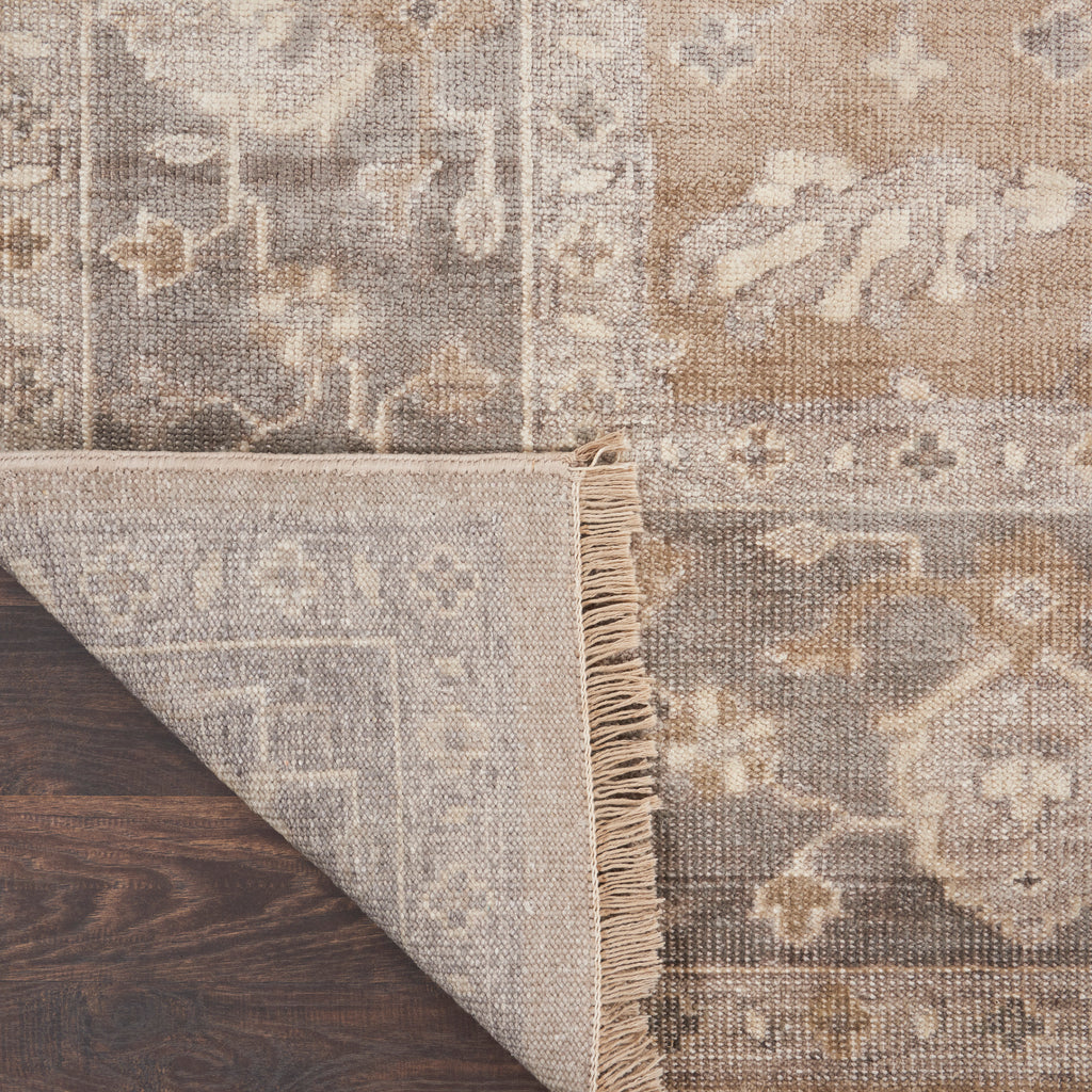 Close-up of traditional area rug on hardwood floor with vintage look.