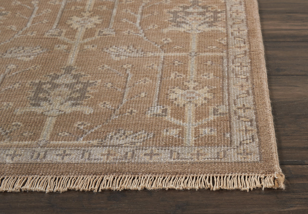 Close-up of botanical patterned rug on dark wood floor.