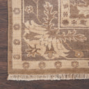 Close-up of a traditional patterned rug with floral motifs on wooden floor.