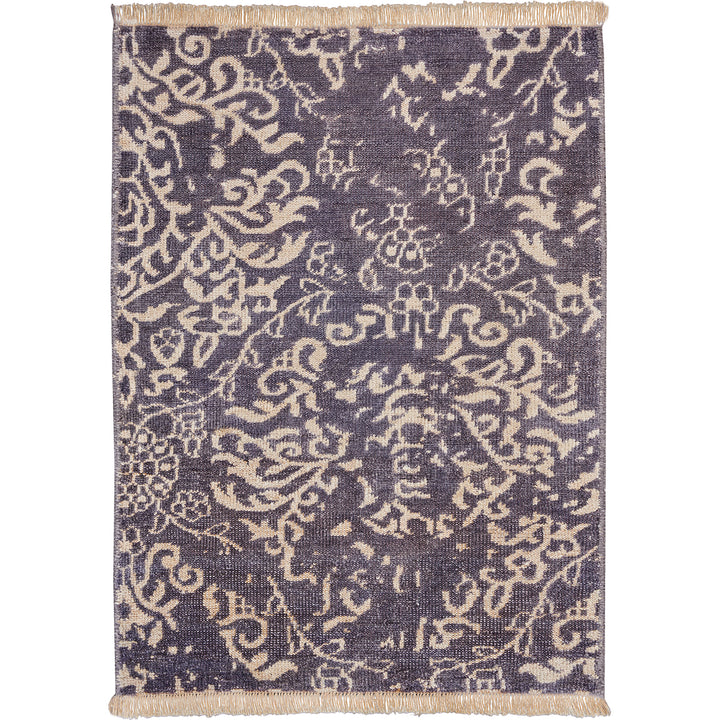 Exquisite antique rug with intricate symmetrical patterns and delicate tassels