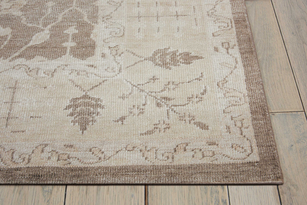 Close-up of a patterned area rug on a wooden floor.