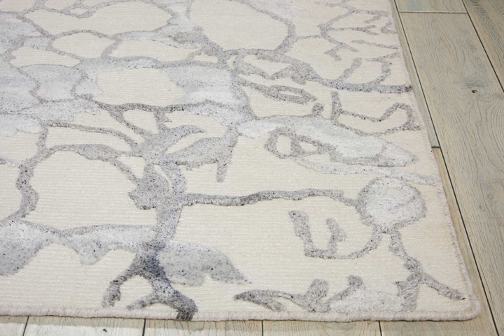 Close-up of an abstract, organic-patterned rug on wooden floor.