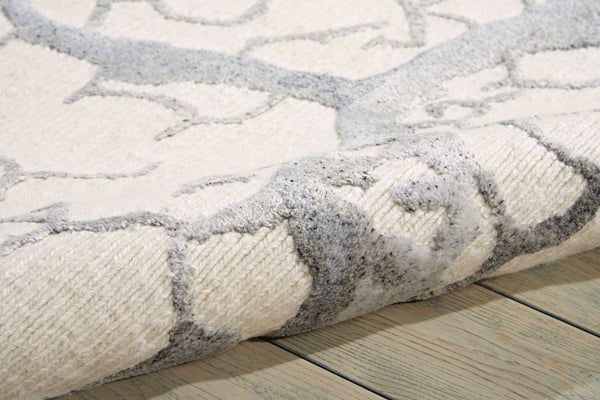Close-up of plush, patterned rug on wooden floor, creating cozy ambiance.