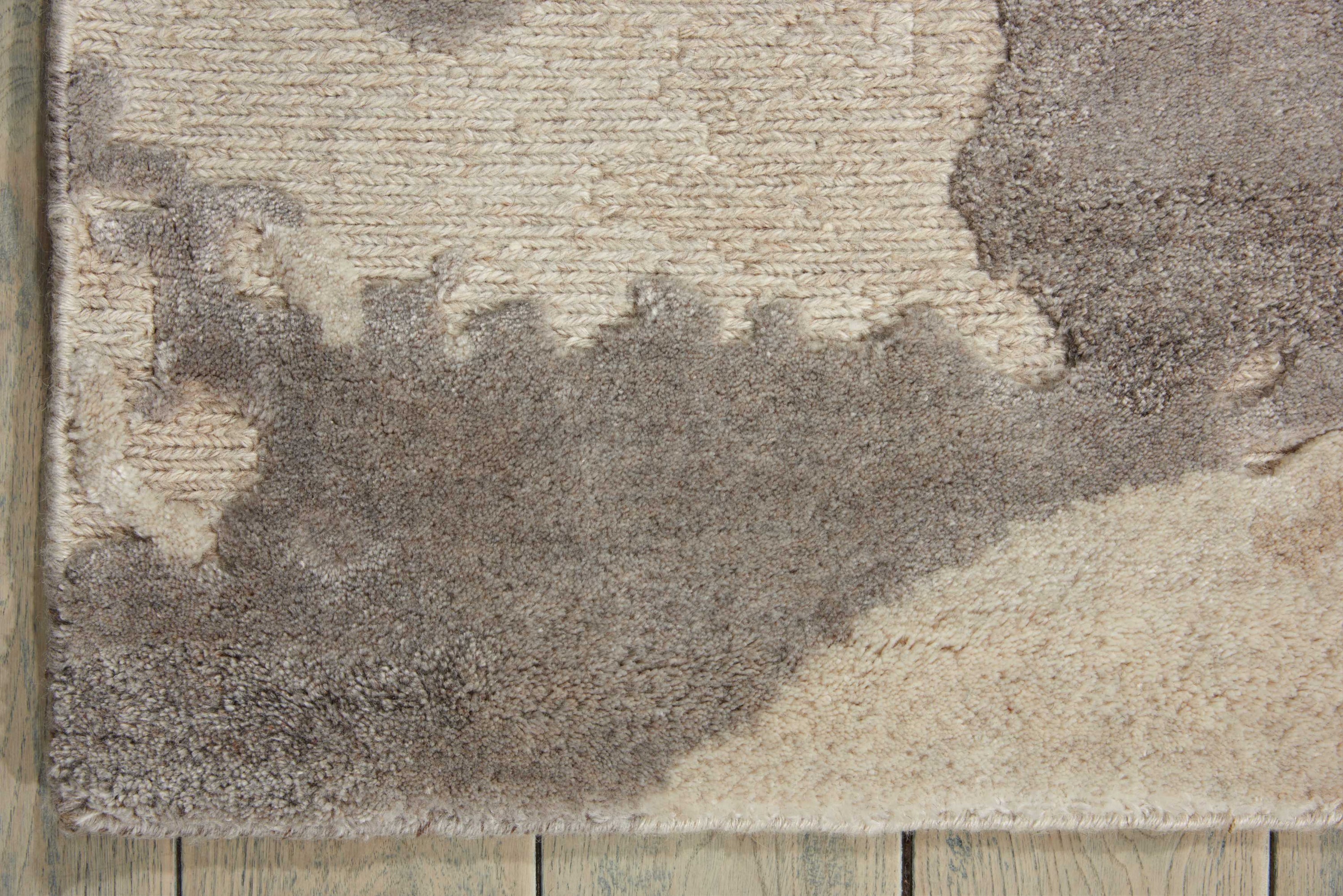 Close-up view of a worn rug with discoloration and textures.