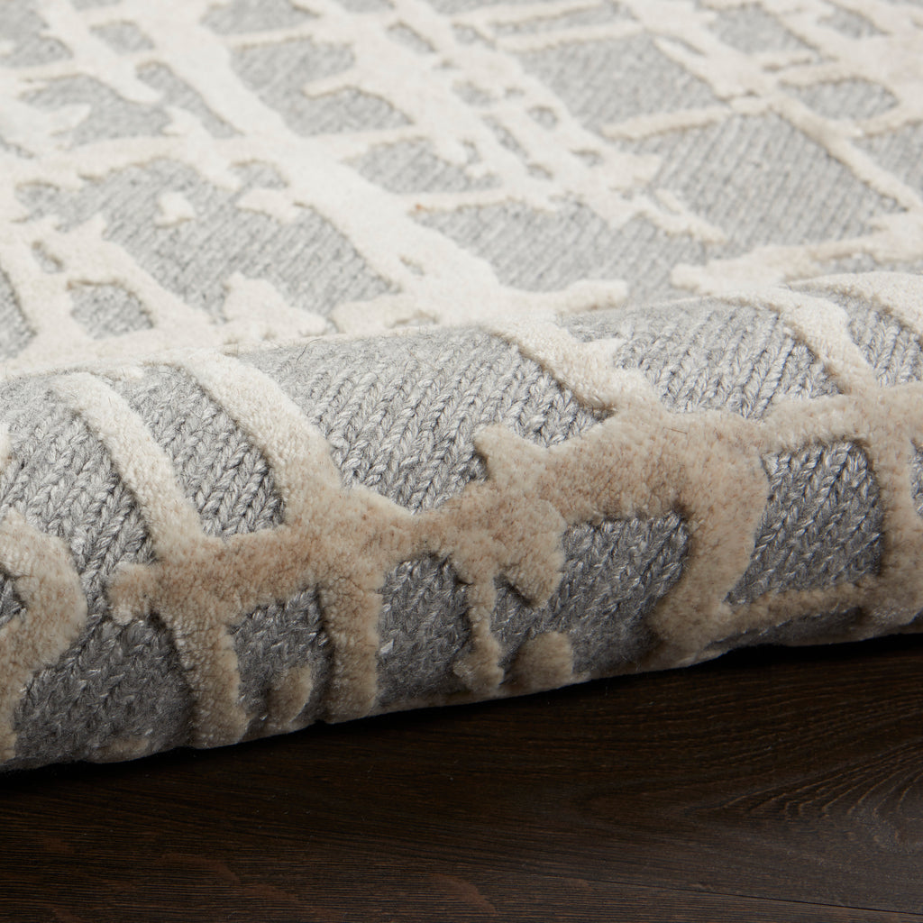 Close-up view of a plush, neutral area rug with geometric design.