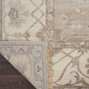 Close-up view of folded rug with decorative pattern on wooden floor.