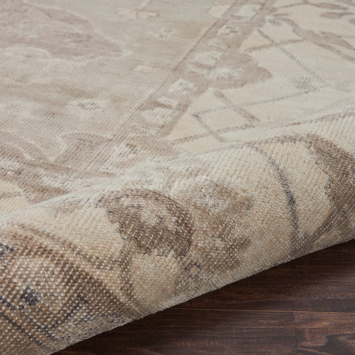 Close-up of a textured, geometric area rug on a wooden floor.