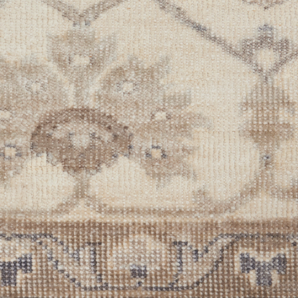 Close-up of a plush, knotted carpet with neutral tones and subtle patterns.