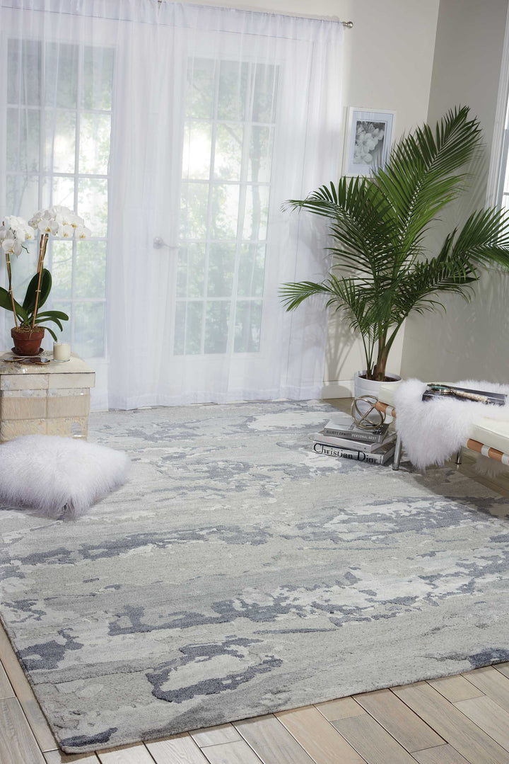 Stylish and modern interior with gray patterned rug and greenery