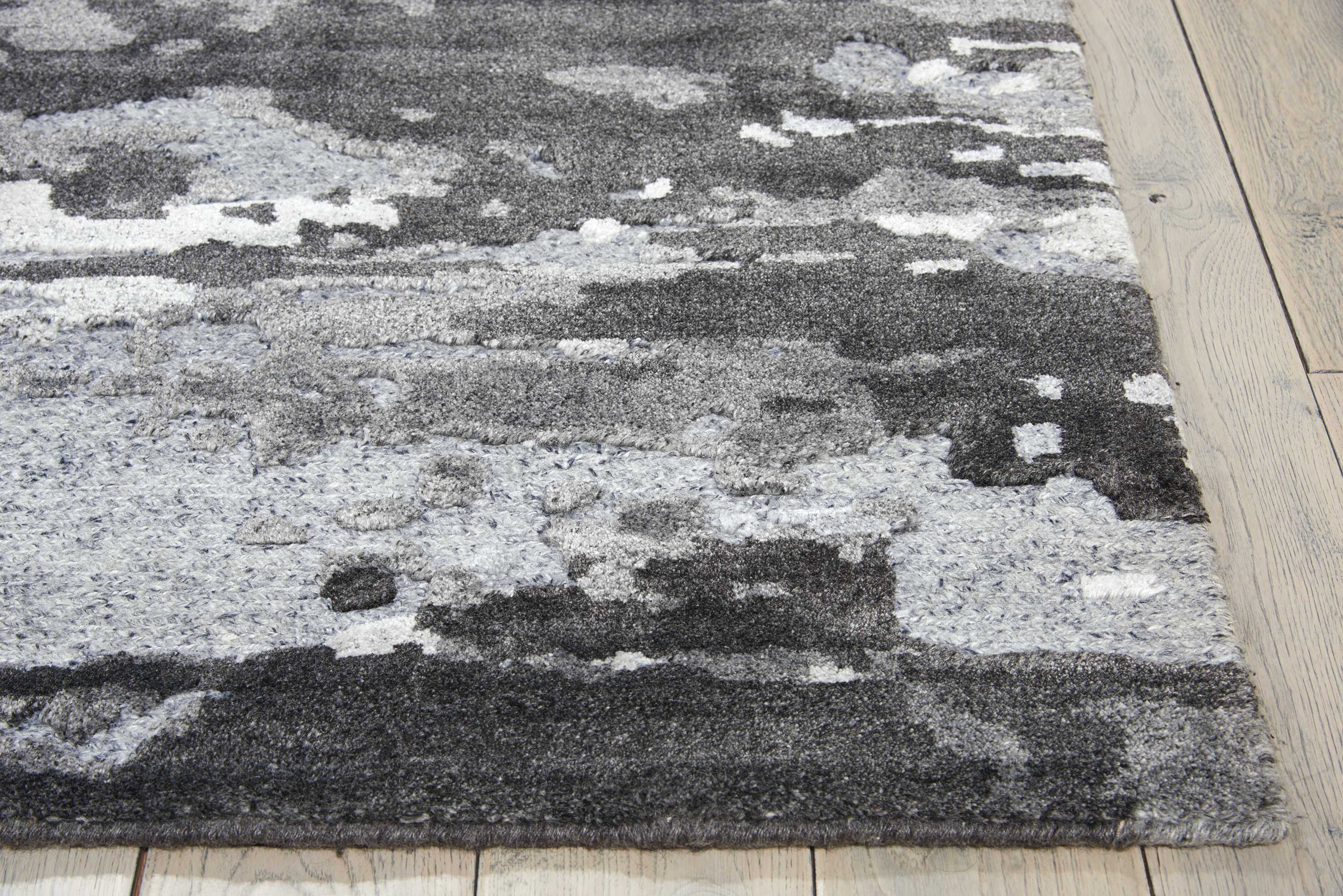 Modern abstract area rug with gradient of grays adds texture.