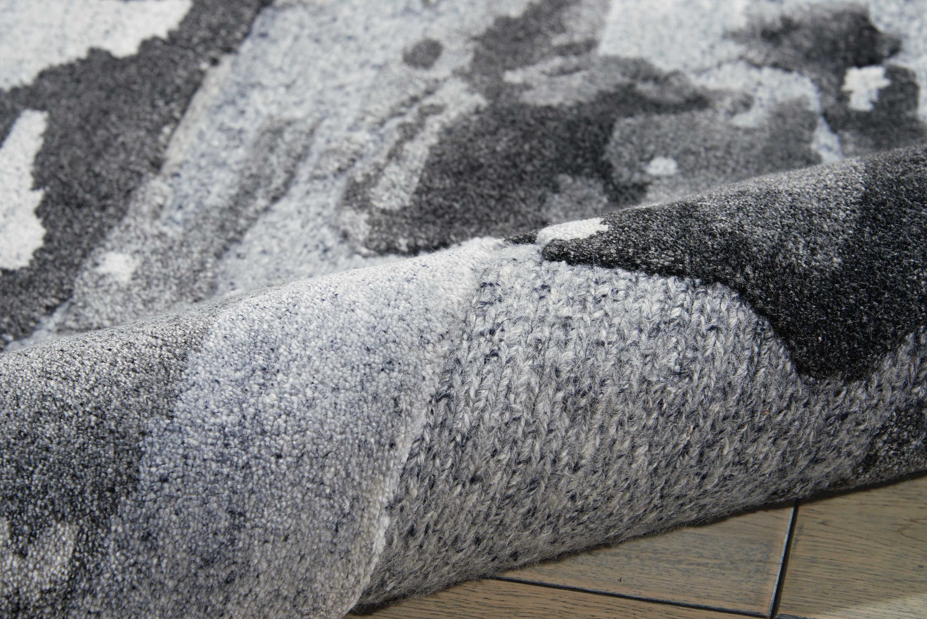 Close-up of a textured gray fabric with tufted yarns.