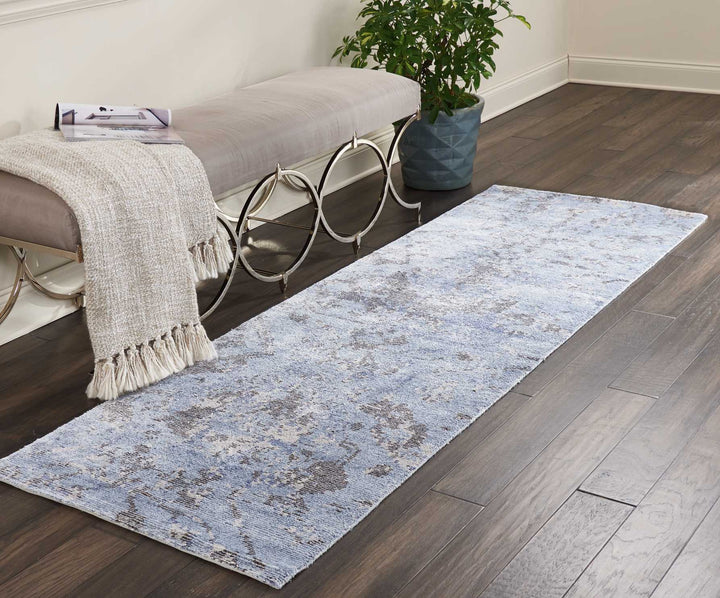 Inviting modern room with distressed blue-gray rug and cozy bench.