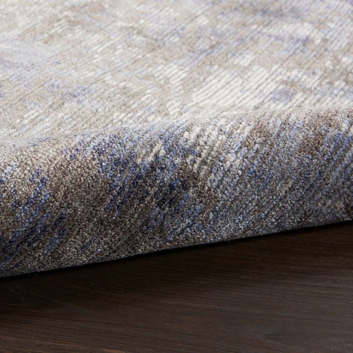 Close-up of a folded area rug with textured design.