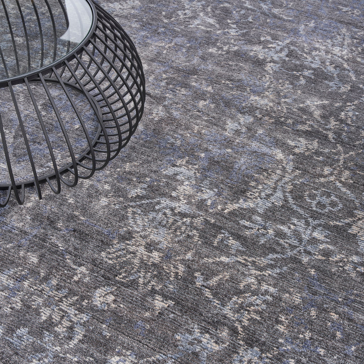 Close-up of a patterned area rug and metal-framed side table.