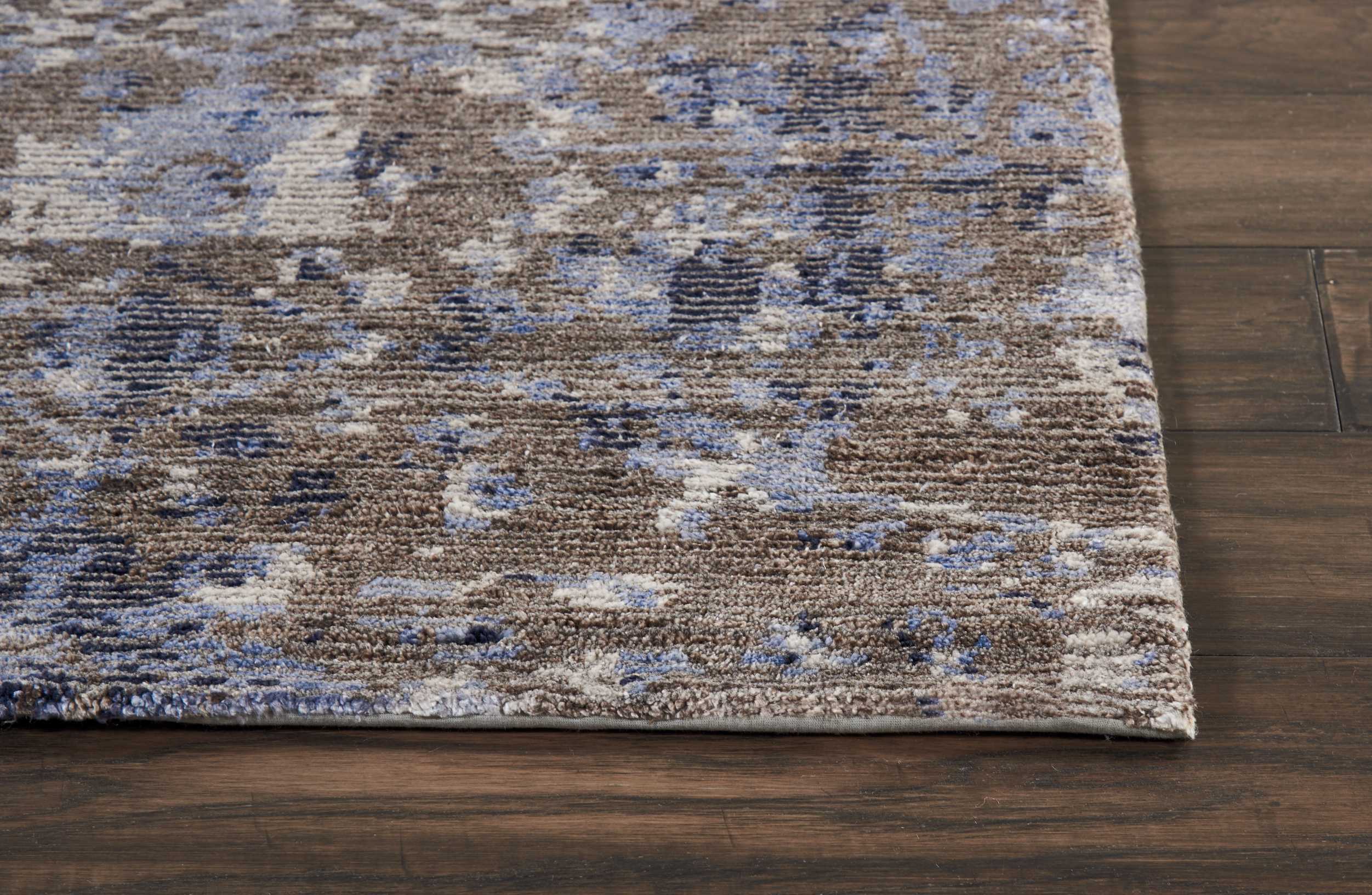 Close-up of textured area rug with abstract, distressed pattern.