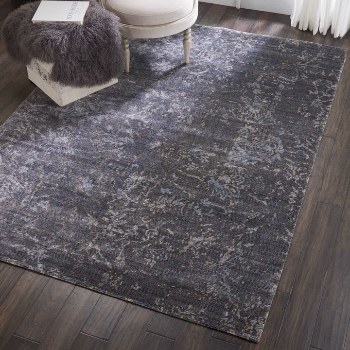 Elegant vintage-style rug on dark hardwood floor in modern interior.