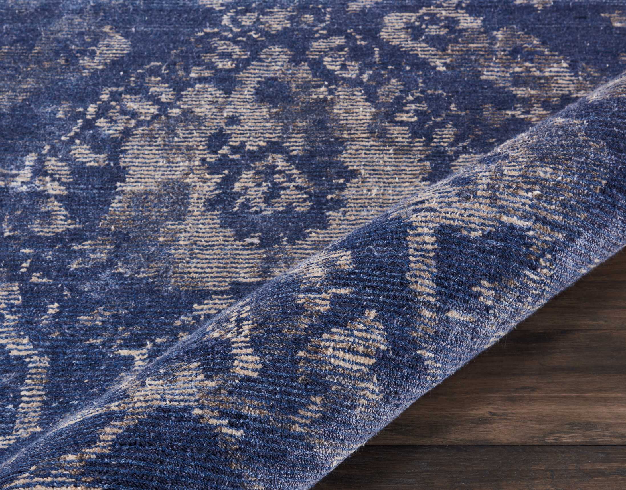 An intricate blue and beige rug showcases its plush fibers.