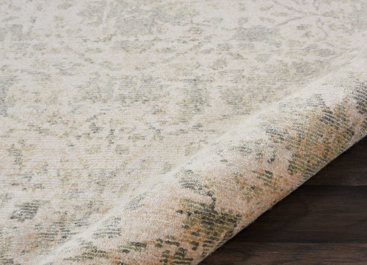 Close-up view of a vintage, distressed carpet on hardwood floor.