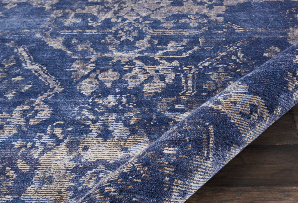 Intricate distressed traditional rug in deep blue with cream patterns.