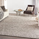 Contemporary living room with geometric rug, glass coffee table, and cozy accents.