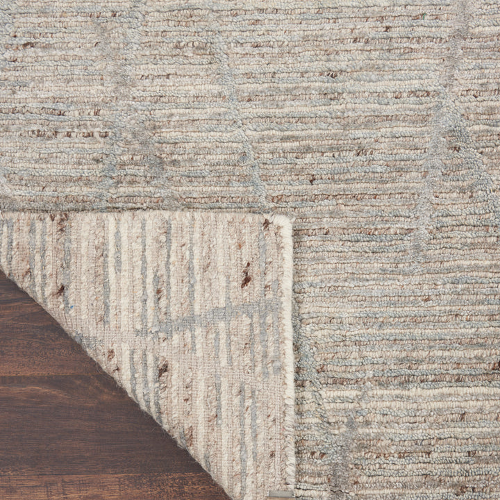Close-up view of a textured rug with earthy tones and blemishes.