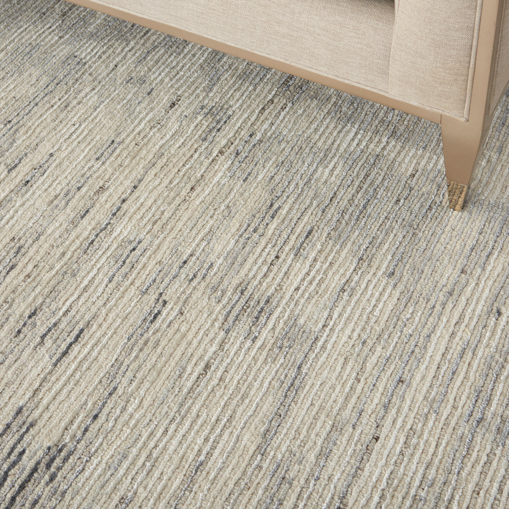 Textured carpet featuring linear pattern in shades of gray and beige, complemented by carefully selected home decor.