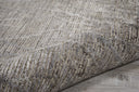 Close-up of ribbed textured carpet on wooden floor with wear.