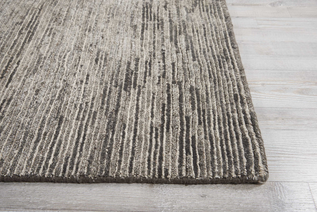 Close-up of a striped area rug on a wooden floor.
