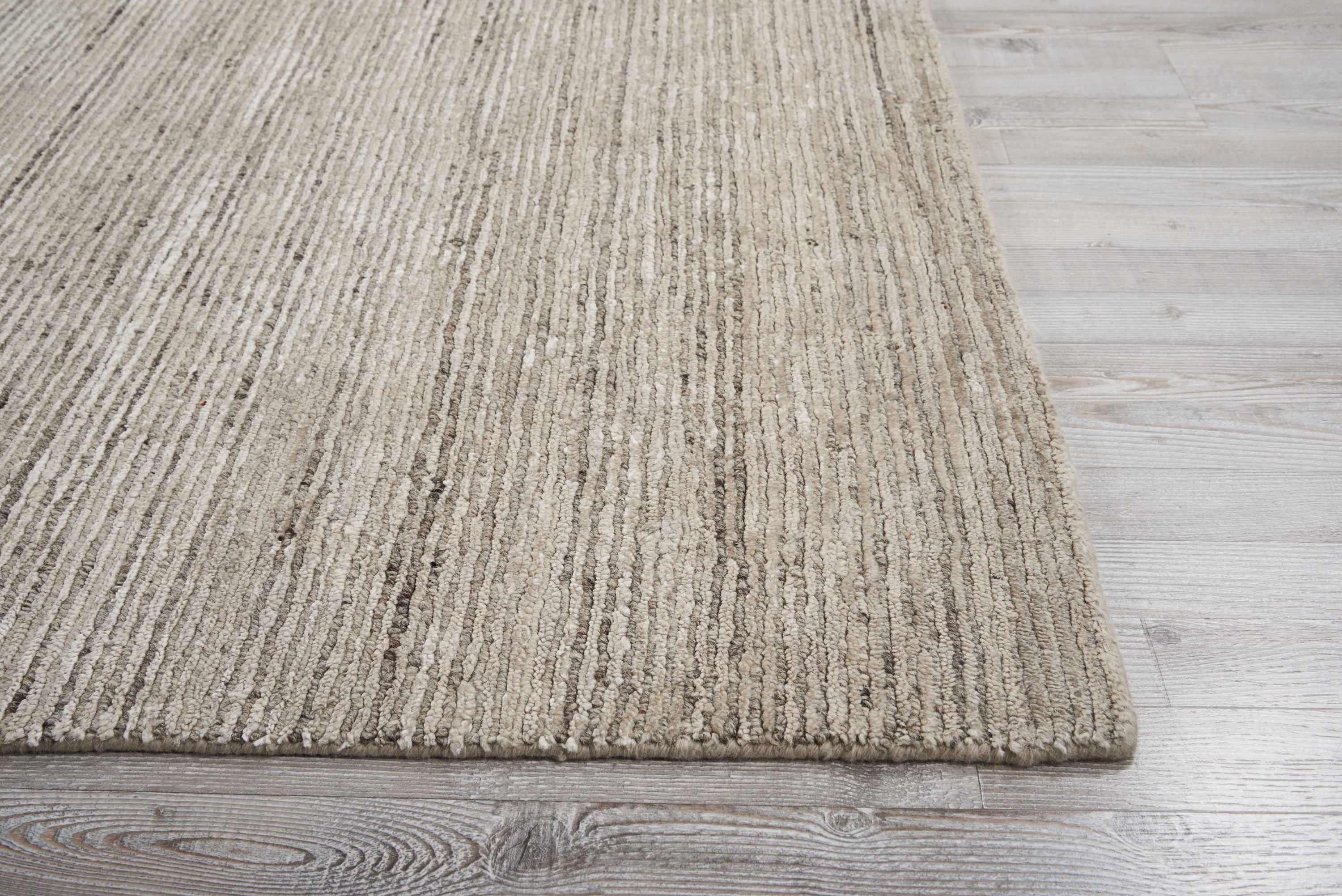 Section of textured area rug on wood laminate floor