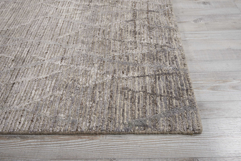 Abstract patterned rug on wooden floor creates modern tactile contrast.