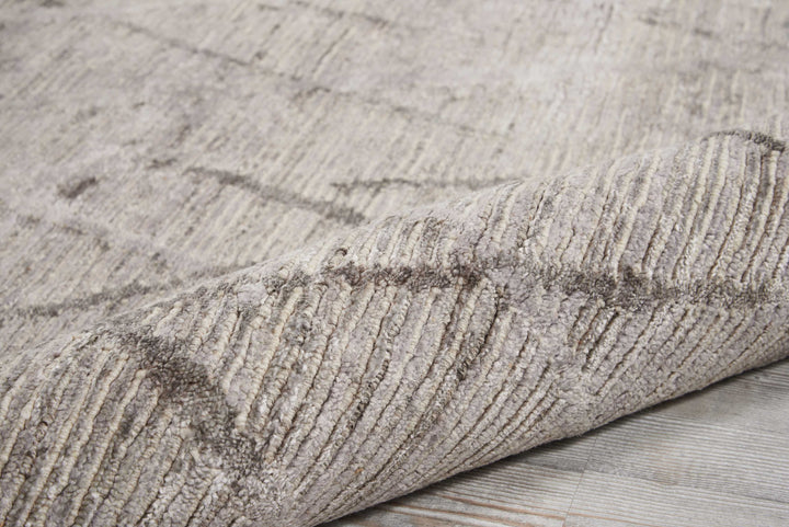 Close-up of textured grey carpet with prominent crease or fold.