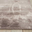 Abstract mauve rug on hardwood floor adds modern aesthetic.
