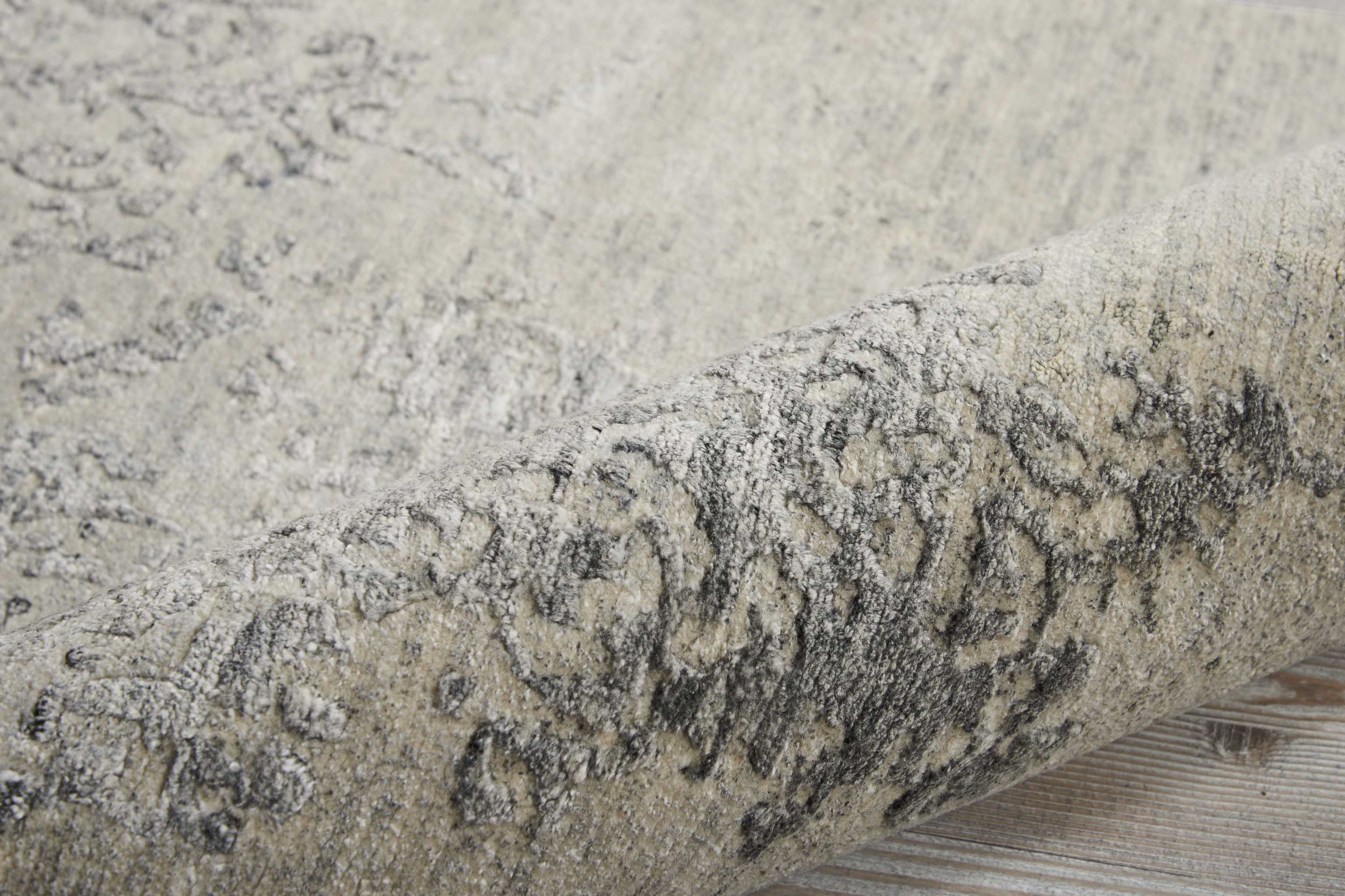 Close-up of a textured, cylindrical rug in black, grey, and white.
