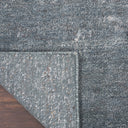 Close-up of a textured grey carpet corner with folded underside