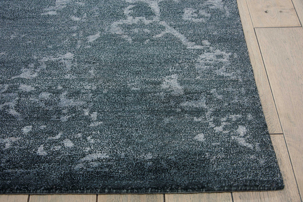 Close-up of a textured, transitional rug on a wooden floor.