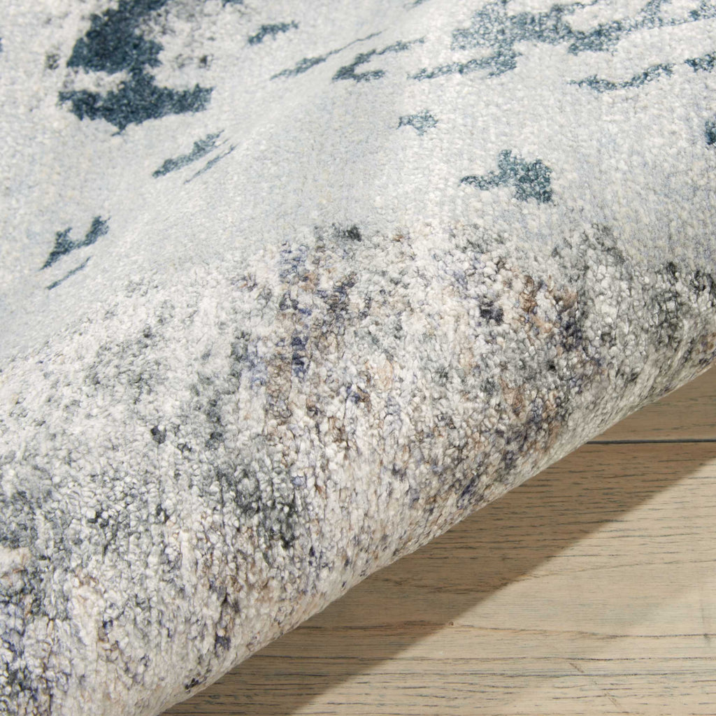Close-up view of a blue and grey patterned textured rug.