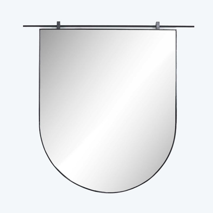 Wall-mounted shield-shaped mirror with secure clips in neutral space.