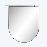 Wall-mounted shield-shaped mirror with secure clips in neutral space.