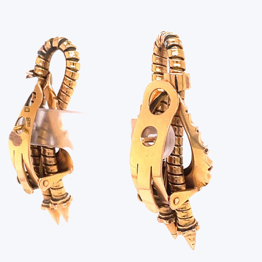 Golden spring-loaded carabiners, potentially decorative items, against white background.