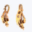 Golden spring-loaded carabiners, potentially decorative items, against white background.