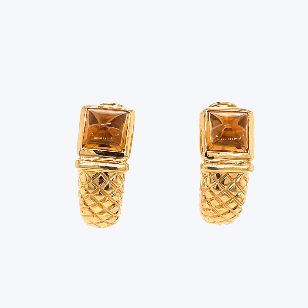 Exquisite gold earrings with geometric design and amber gemstone detail.