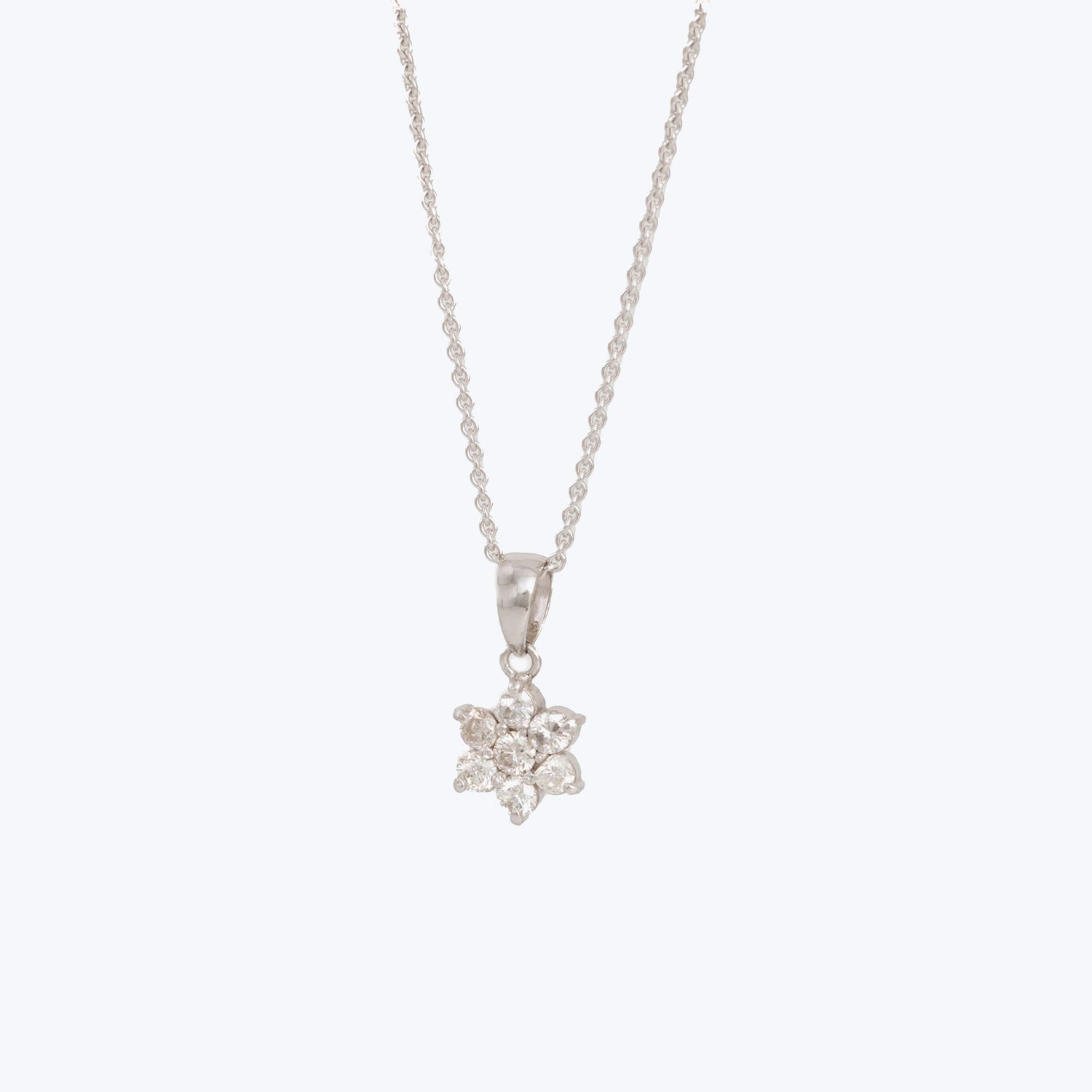 Elegant silver necklace with flower pendant adorned with sparkling stones.