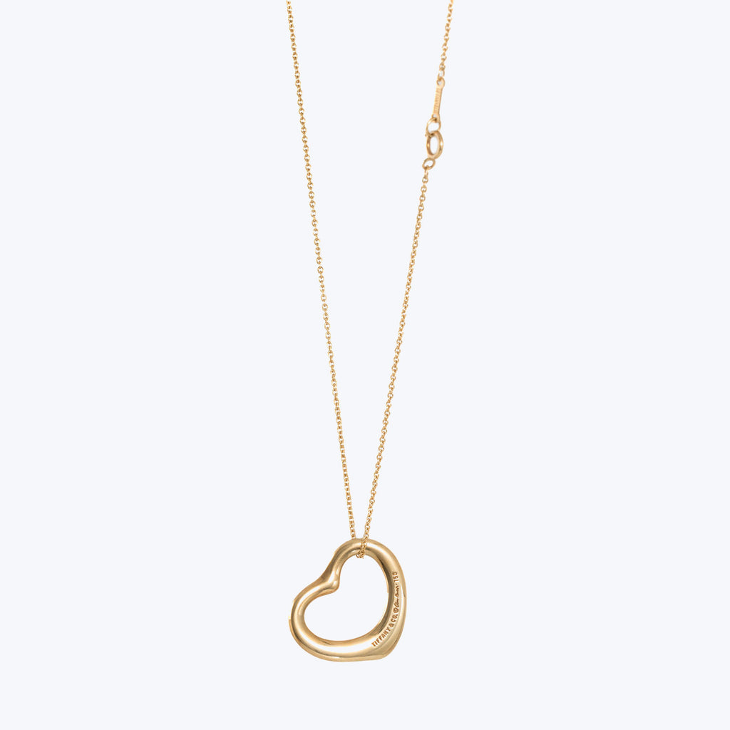 Gold necklace with a heart-shaped pendant on delicate cable chain.