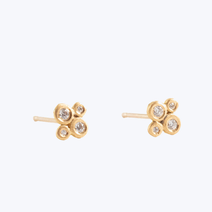 Gold-colored, clustered earrings with clear stone accents in flower design.
