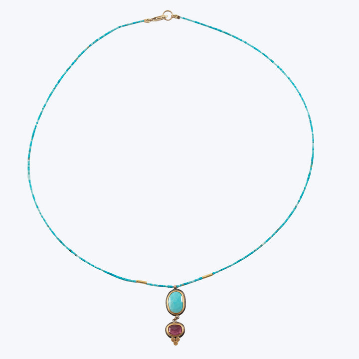 Elegant handcrafted necklace with turquoise and amethyst gemstones on chain.