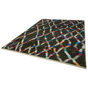 Vibrantly colored patterned rug with intricate geometric design on black background.